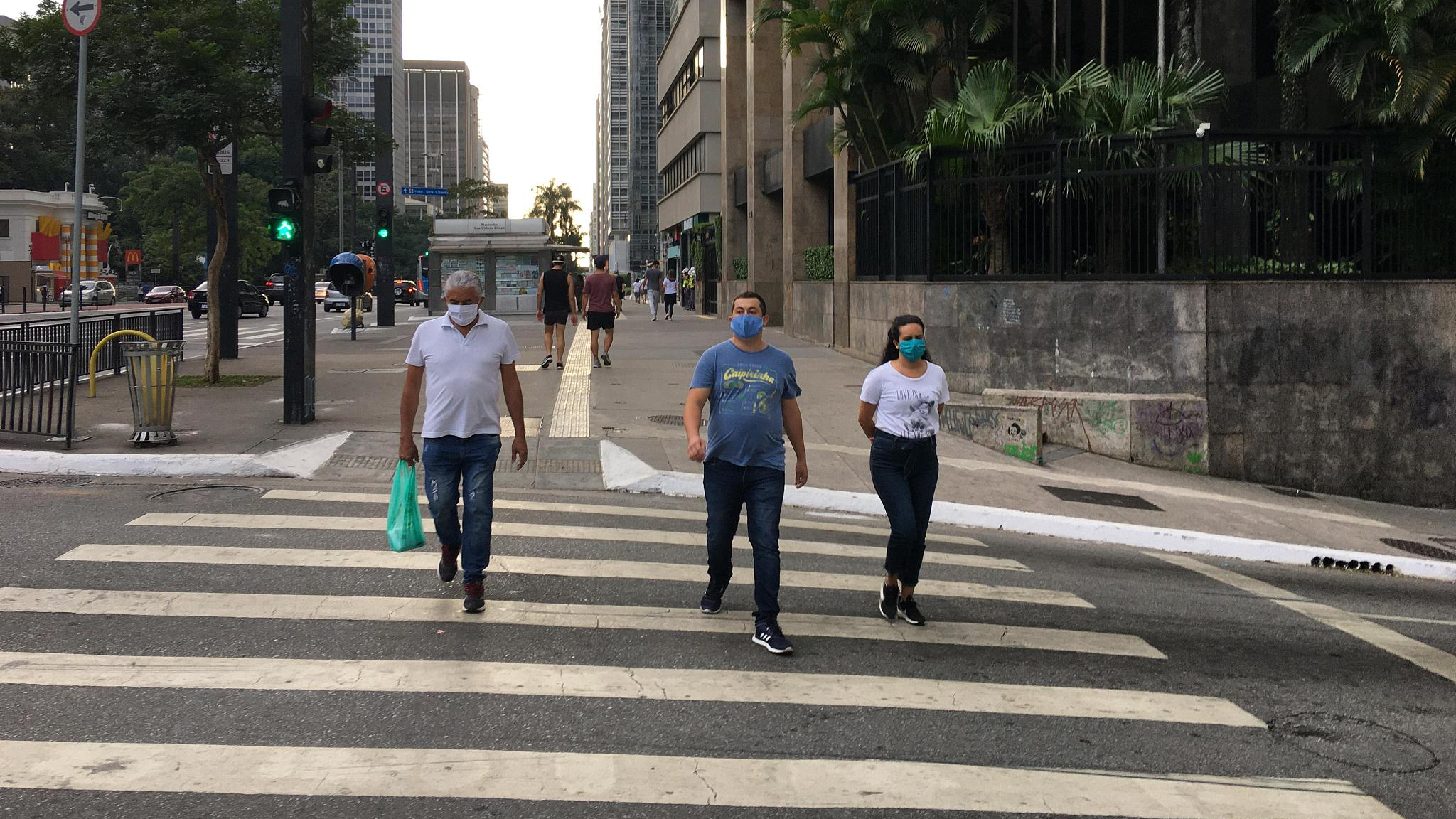 People wearing masks walk on a street in Sao Paulo, Brazil, May 1, 2020. /CFP