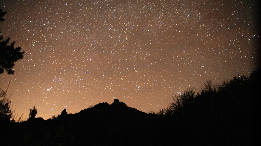 A Leonid meteor shower streaks across the sky above the Jinshanling Great Wall in Luanping County, Chengde City of north China's Hebei Province, December 15, 2021. /CFP