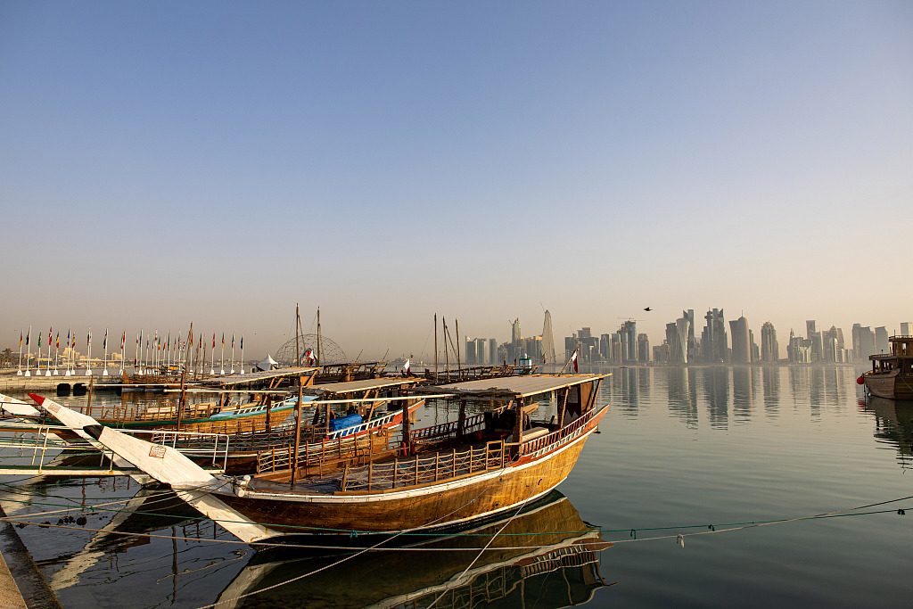Traditional boats float on the water in front of residential and commercial skyscrapers in Doha, Qatar, June 23, 2022. About 1.5 million fans, a little more than half the population of Qatar, are expected to visit the Gulf state for this year's World Cup. /CFP