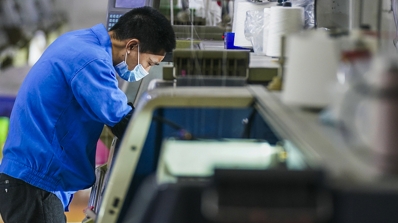 A worker is busy on the assembly line in a clothing processing workshop in Xinyu City, Jiangxi Province, China. /VCG