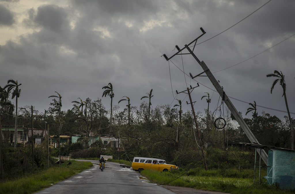 A classic American car drives past utility poles tilted by Hurricane Ian in Pinar del Rio, Cuba, September 27, 2022. /CFP