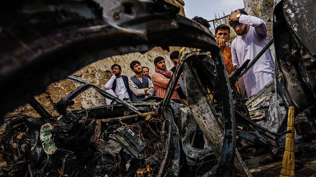 Relatives and neighbors of the Ahmadi family gathered around the incinerated husk of a vehicle hit by an American drone strike that killed 10 people, including children, in Kabul, Afghanistan, August 30, 2021. /CFP