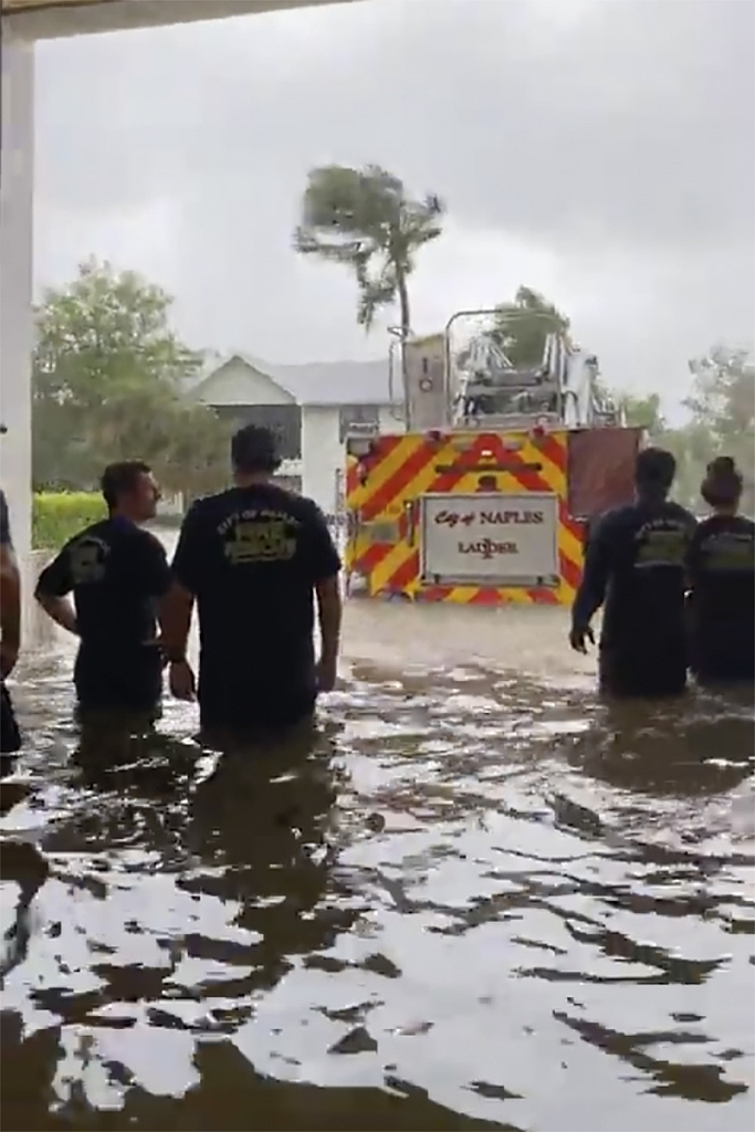This image provided by the Naples Fire Rescue Department shows firefighters look out at a firetruck that stands in water from the storm from Hurricane Ian on Wednesday, Sept. 28, 2022 in Naples, Fla. Hurricane Ian has made landfall in southwestern Florida as a massive Category 4 storm. /VCG