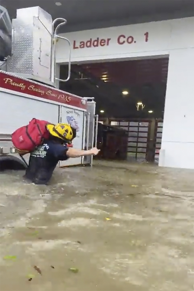 This image provided by the Naples Fire Rescue Department shows a firefighter carrying gear in water from the storm surge from Hurricane Ian on Wednesday, Sept. 28, 2022 in Naples, Fla. Hurricane Ian has made landfall in southwestern Florida as a massive Category 4 storm. /VCG