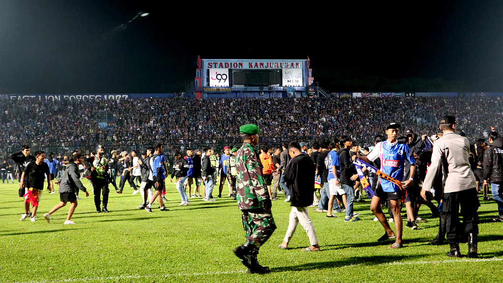 Football supporters entered the pitch as security officers tried to disperse them during a riot following a soccer match at Kanjuruhan Stadium in Malang, East Java, Indonesia, October 1, 2022. /CFP
