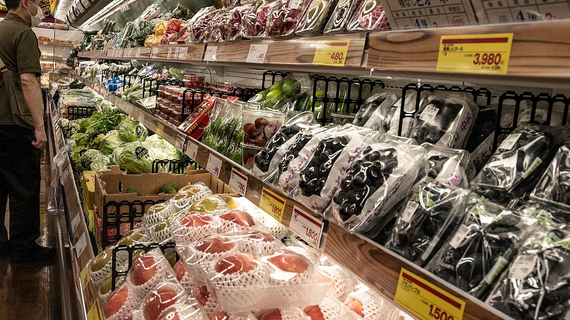 This photo taken on August 17, 2022 shows a shopper looking at fresh produce at a supermarket in Tokyo./ VCG