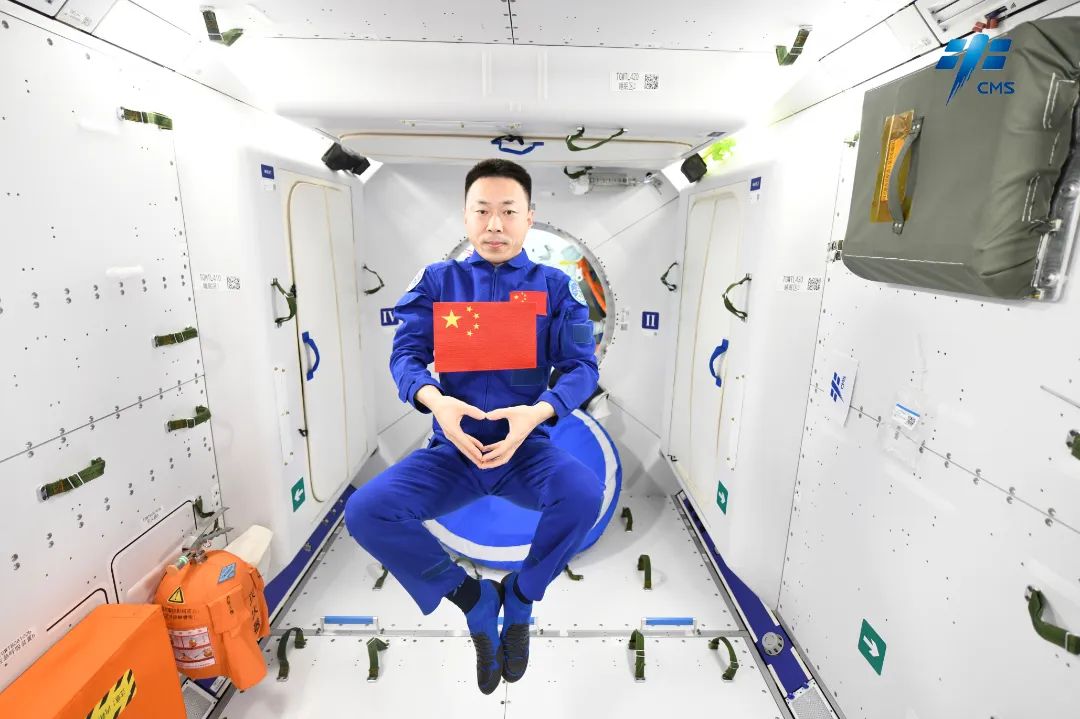 Taikonaut Cai Xuzhe poses for a photo with the Chinese national flag. /CMSA