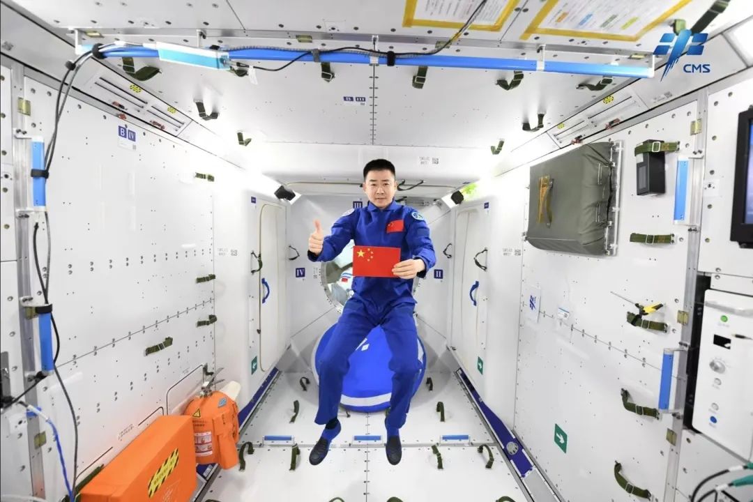 Taikonaut Chen Dong poses for a photo with the Chinese national flag. /CMSA