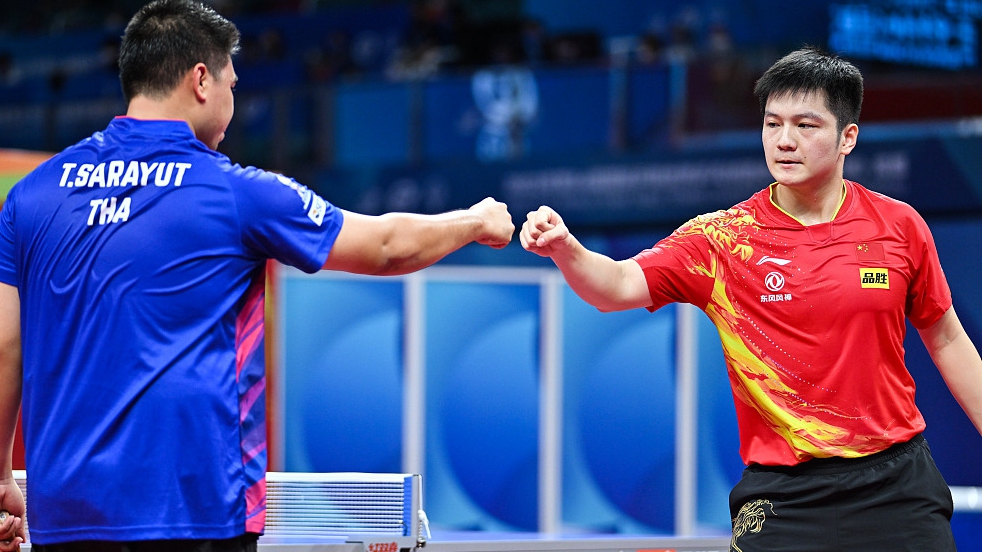 China's Fan Zhendong fist-bumps Thailand's Sarayut Tangcharoen during their group clash at the World Team Table Tennis Championships in Chengdu, China, October 4, 2022. /CFP