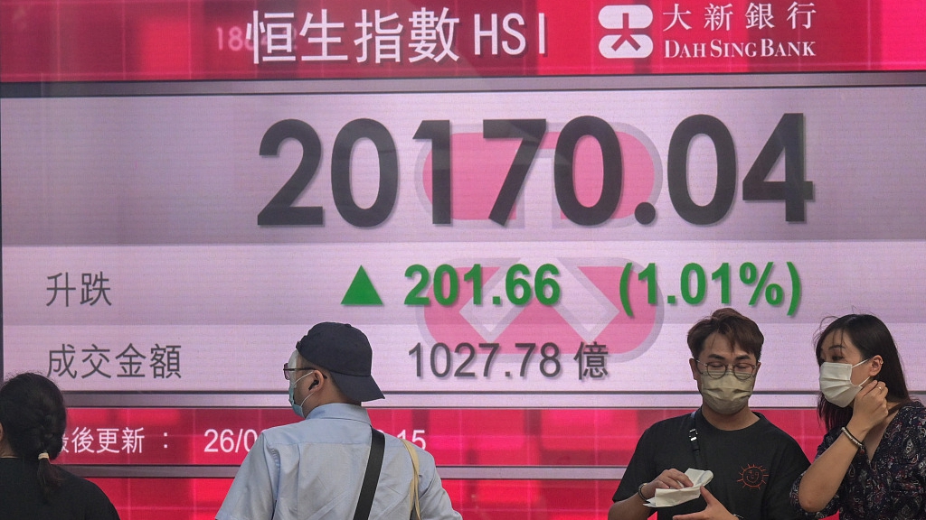 People walk past a screen displaying the Hang Seng stock index in Hong Kong, China, August 26, 2022. /CFP
