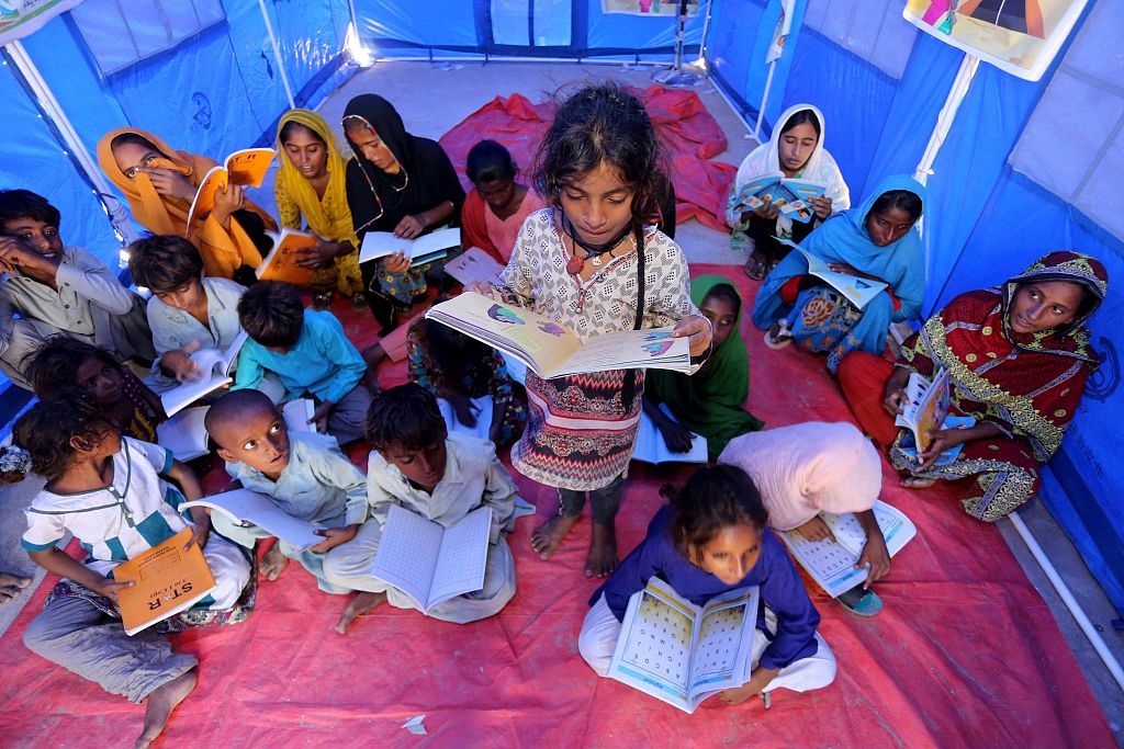 Flood-affected children attend a class in a makeshift shelter built with tents donated by China in flood relief aid in Sindh, Pakistan, September 21, 2022. /CFP   