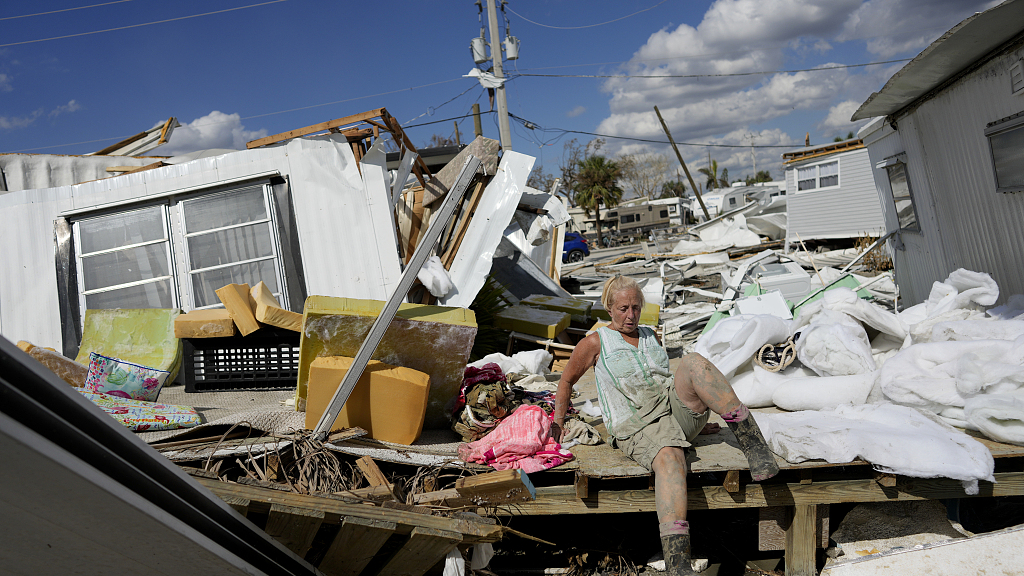 A woman climbs across a hurricane-ruined scene in Fort Myers Beach, Florida, the U.S., October 5, 2022. /CFP