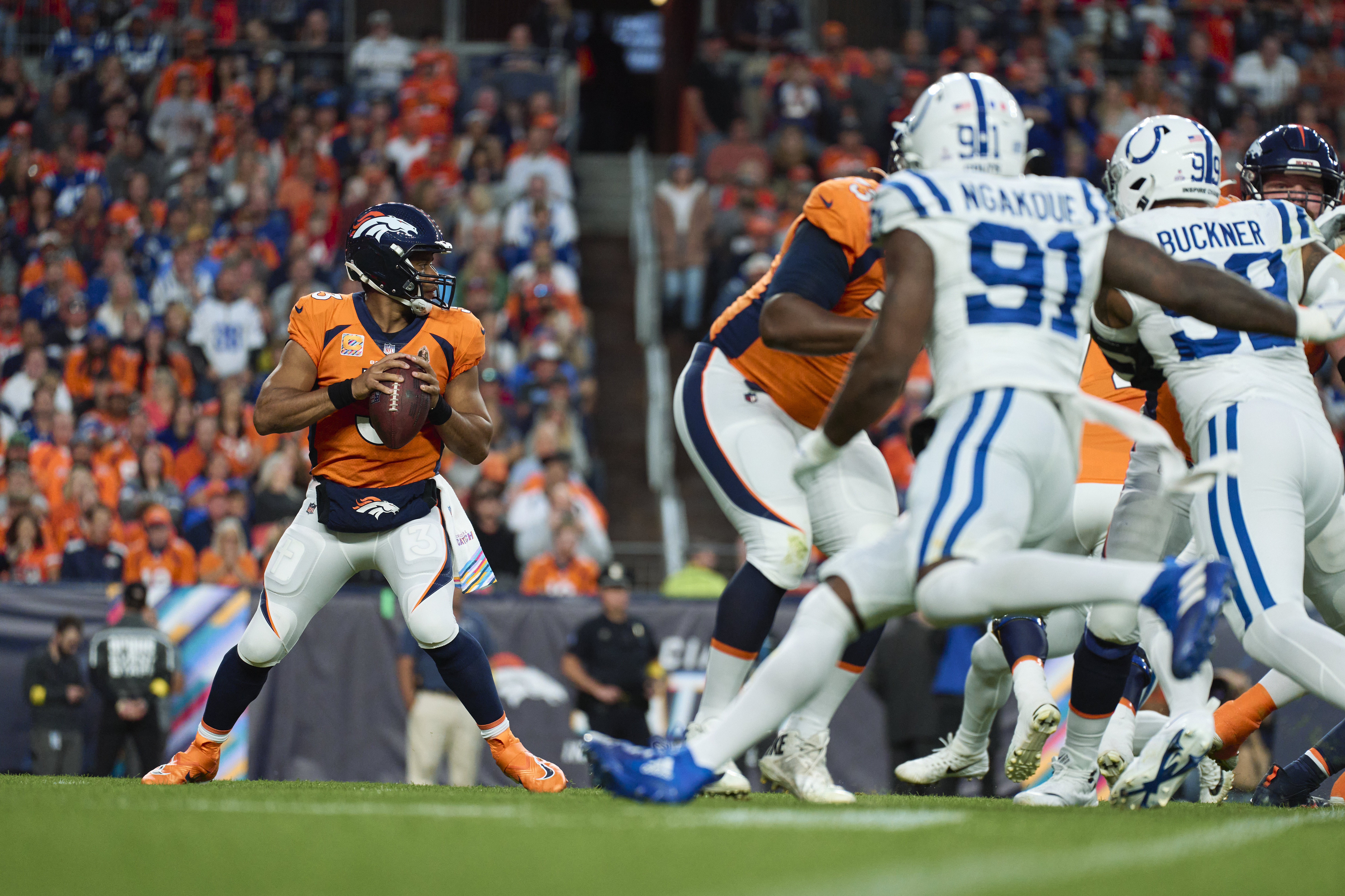 Quarterback Russell Wilson (L) of the Denver Broncos looks to pass in the game against the Indianapolis Colts at Mile High in Denver, Colorado, October 6, 2022. /CFP