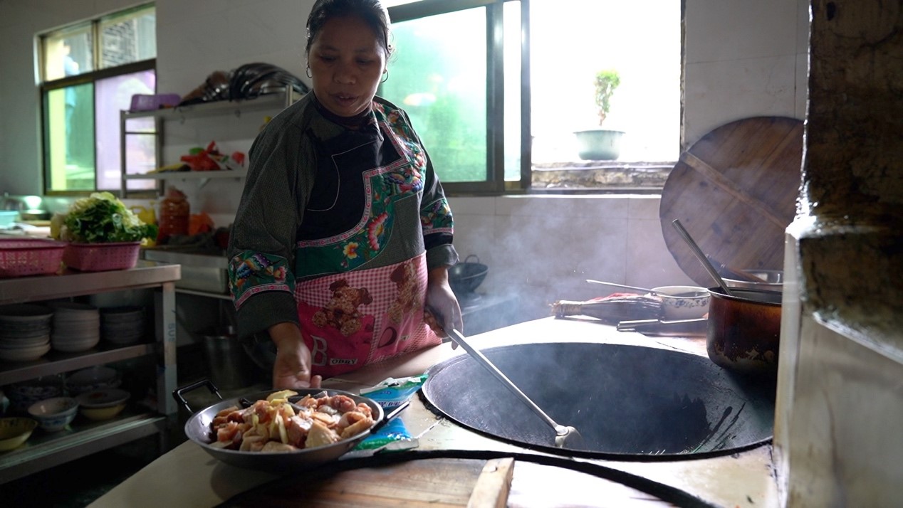 Villager Long Xinghua is preparing lunch. /CGTN