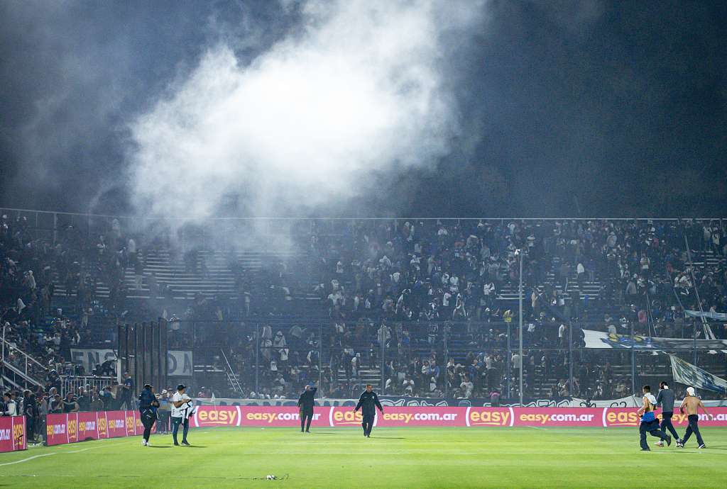 Fans of Gimnasia y Esgrima react in the field after being affected by tear gas during the match against Boca Juniors in La Plata, Argentina, October 6, 2022. /CFP