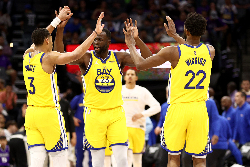 L-R: Jordan Poole, Draymond Green and Andrew Wiggins of the Golden State Warriors celebrate after the team scores in the game against the Sacramento Kings at Golden 1 Center in Sacramento, California, April 3, 2022. /CFP