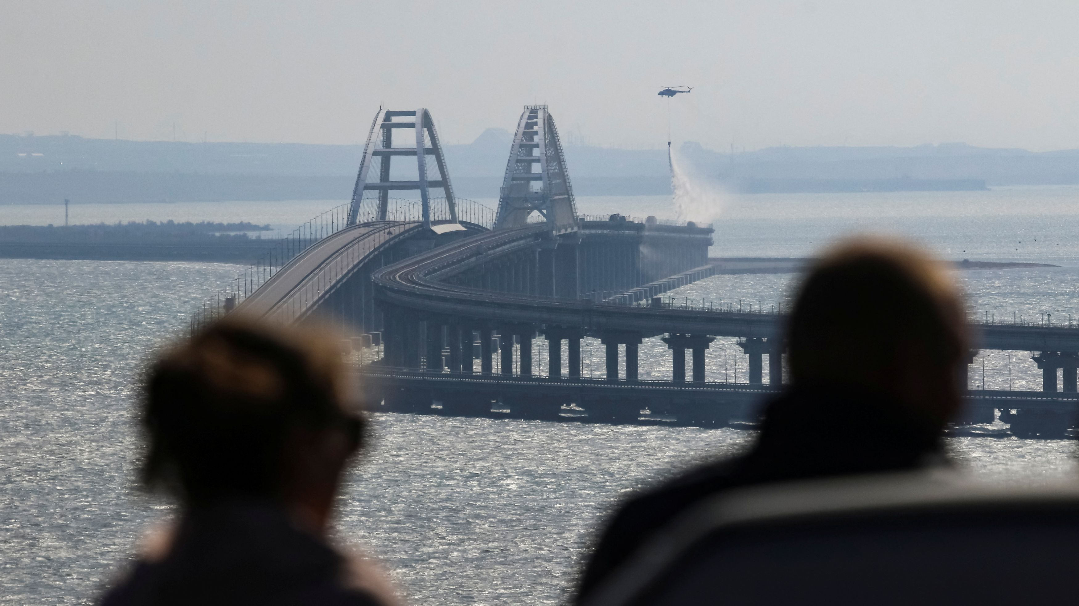 People watch burning fuel tanks on the Kerch bridge in the Kerch Strait, Crimea, October 8, 2022. /Reuters