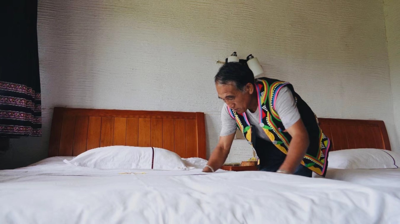Li Shikai makes a bed at home to accommodate visitors.  Luo Caiwen/CGTN