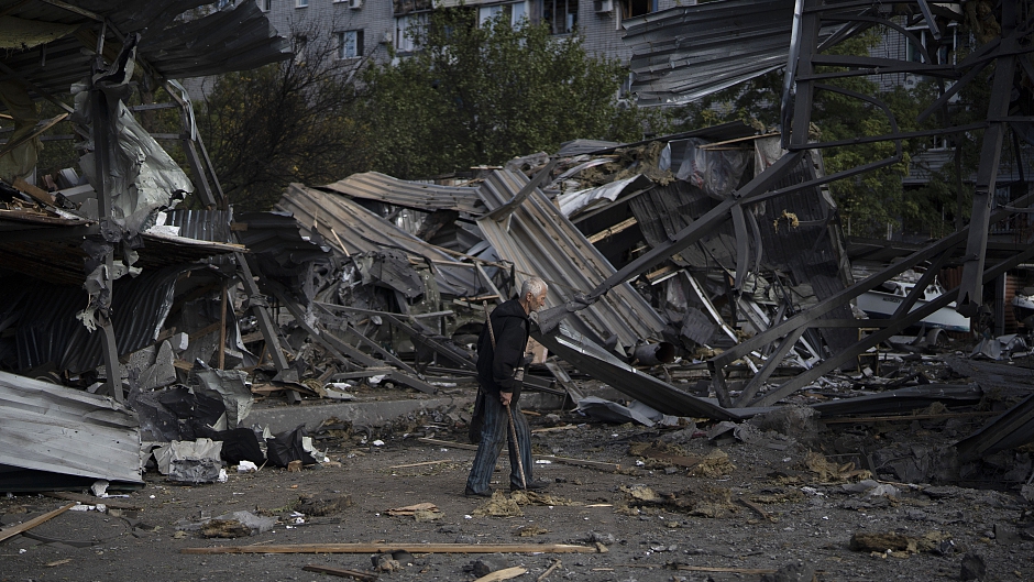 An elderly man walks past a car shop that was destroyed after attack in Zaporizhzhia, Ukraine, October 11, 2022. /CFP