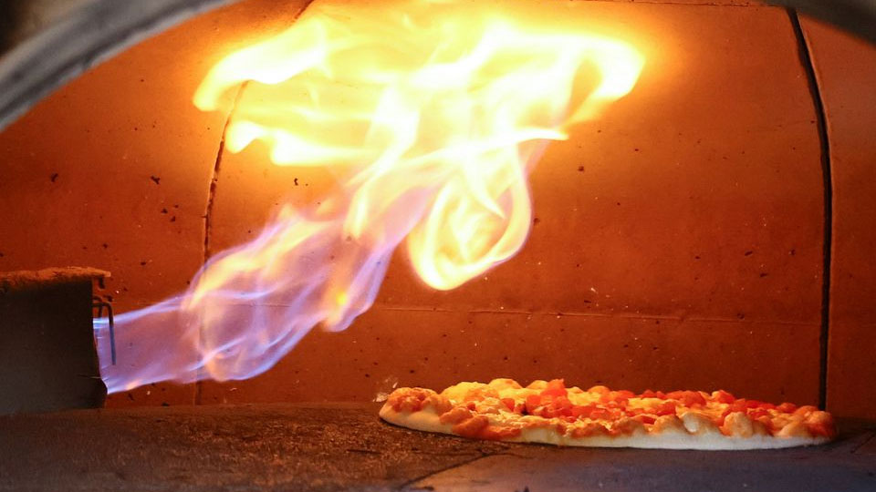 A pizza is baked in a traditional Italian oven fired with natural gas, at a restaurant in Bonn, Germany, October 11, 2022. /Reuters

