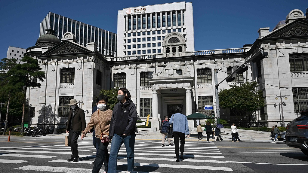Pedestrians cross a road in front of the Bank of Korea headquarters in Seoul, South Korea, October 12, 2022. /CFP