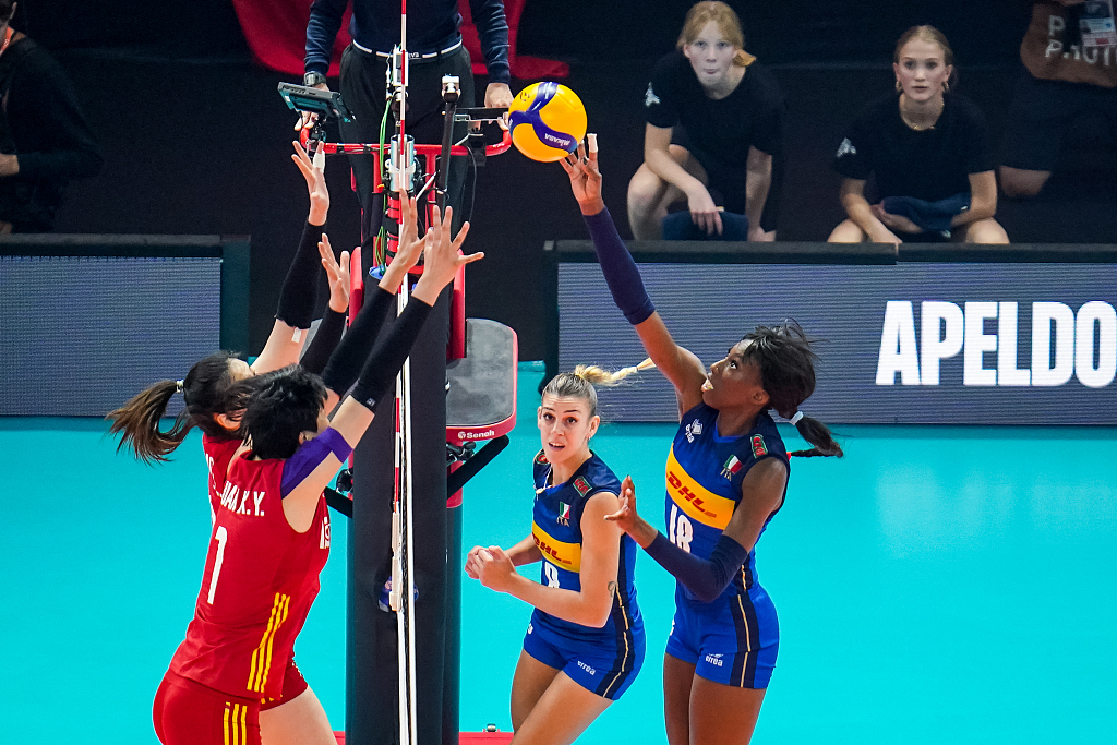 Chinese players (in red) form a block while Paola Egonu of Italy tips the ball at the net during the quarterfinal match against Italy at the FIVB Volleyball Women's World Championship in Apeldoorn, Netherlands, October 11, 2022. /CFP