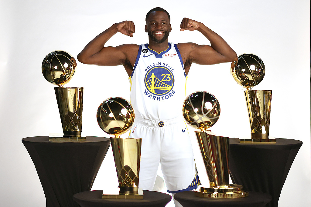 Draymond Green of the Golden State Warriors poses for a photo with the four Larry O'Brien NBA Championship Trophies he has won with the team on meida day in San Francisco, California, September 25, 2022. /CFP
