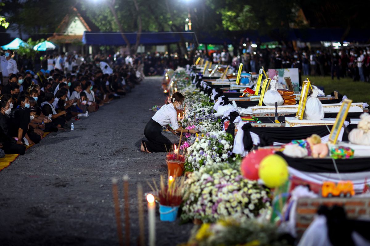 A person pays respects at the coffins of the victims, on the day of cremation at Wat Rat Samakee temple, following a mass shooting at a nursery school, in Uthai Sawan city, Nong Bua Lam Phu province, Thailand.  October 11, 2022. /Reuters 