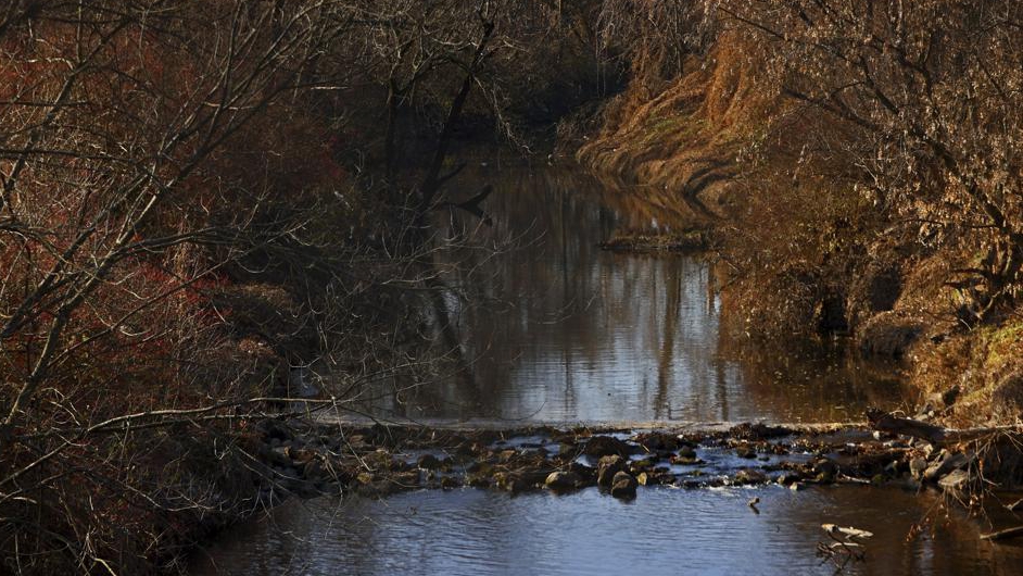 Water flows in Coldwater Creek, behind a row of homes at Belcroft Drive and Old Halls Ferry Road in Missouri's St. Louis County, U.S., December 9, 2021. /AP