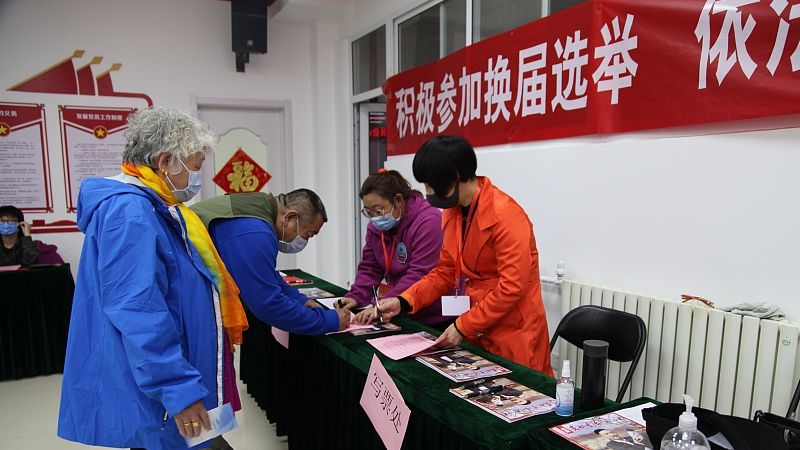 Residents in Dongcheng District filling in voting information for local neighborhood committee election in Beijing, China, April 17, 2021. /CFP
