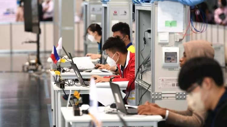 Li Xiaosong (C), a student from Chongqing College of Electronic Engineering, participates in a contest during the WorldSkills Competition 2022 Special Edition in Kyoto, Japan, October 18, 2022. /Xinhua