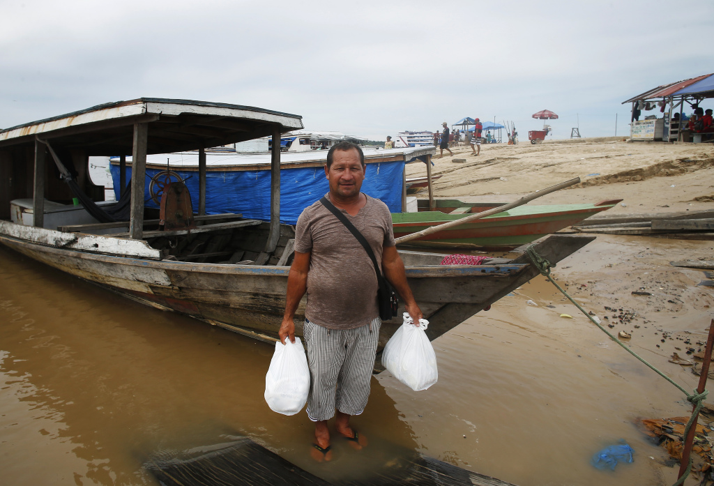 Pedro Canizio da Silva poses with food in an area impacted by the drought near the Solimões River in Tefe, Amazonas state, Brazil, October 19, 2022. /CFP 