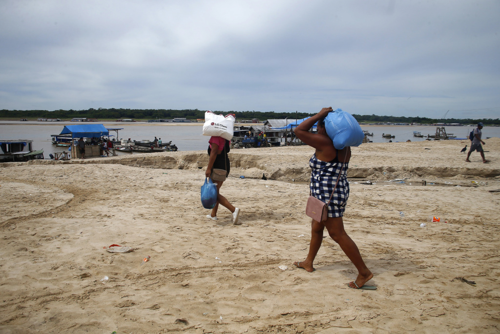 People walk with food in an area impacted by the drought near the Solimões River in Tefe, Amazonas state, Brazil, October 19, 2022. /CFP