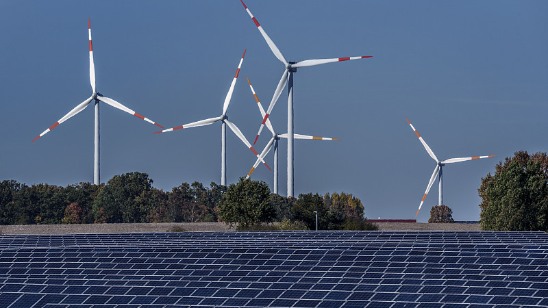Wind turbines turn behind a solar farm in Rapshagen, Germany, October 28, 2021. /CFP