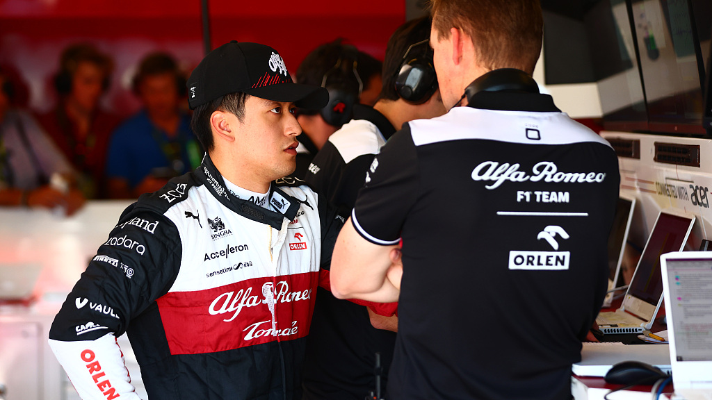 Zhou Guanyu of China (L) and Alfa Romeo F1 team members stand in the garage prior to the final practice of the U.S. Grand Prix qualifier at Circuit of the Americas in Austin, U.S., October 22, 2022. /CFP