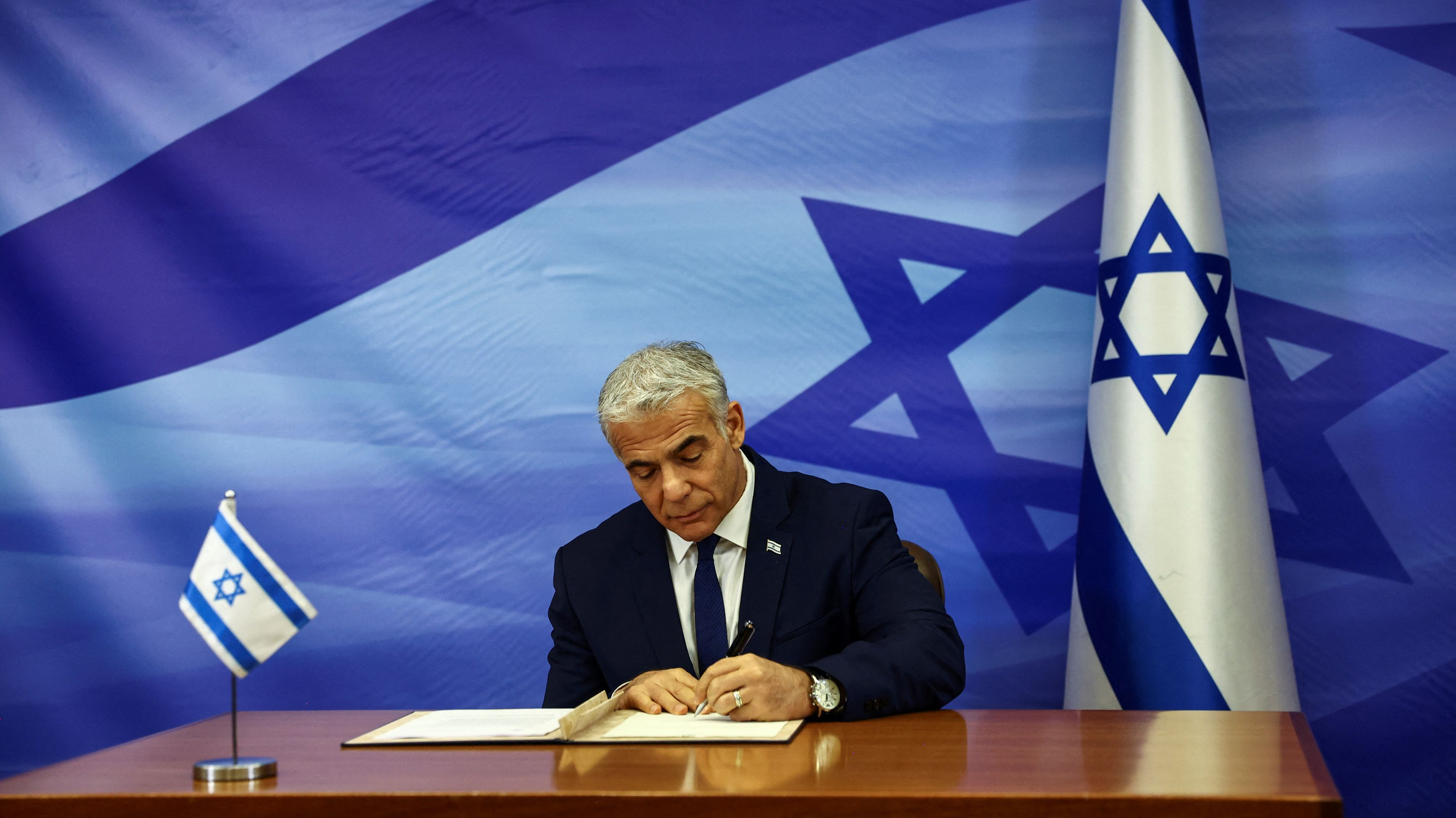 Israeli Prime Minister Yair Lapid signs a U.S.-brokered deal setting a maritime border between Israel and Lebanon at the Prime Minister's office in Jerusalem, Israel, October 27, 2022. /Reuters