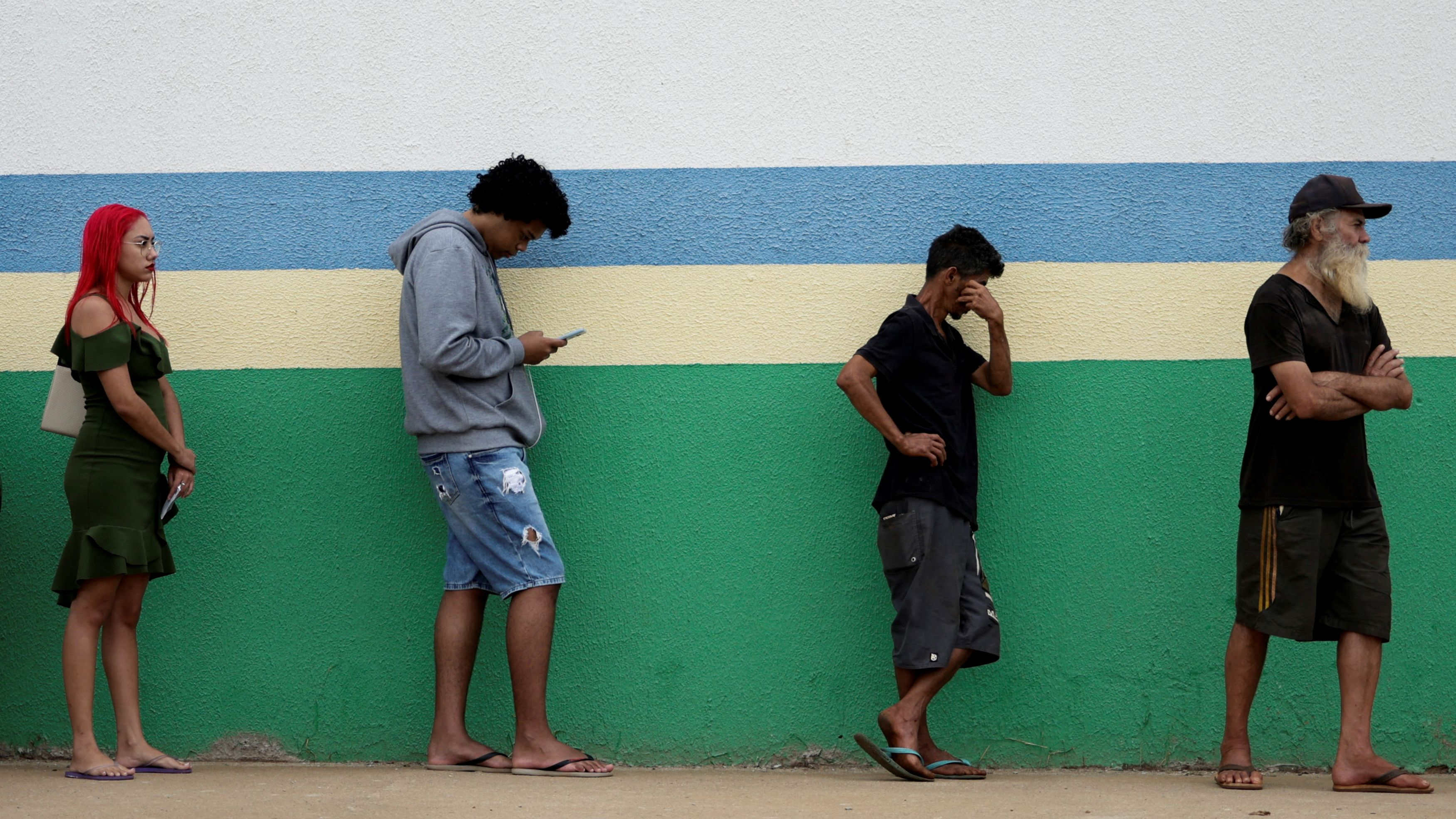 People stand in line to cast their votes outside a polling station, in Aguas Lindas, Brazil, October 30, 2022. /Reuters