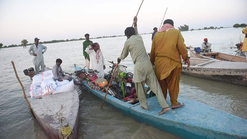 Internally displaced people use a boat to cross the flooded area in Dadu district, Sindh, Pakistan, September 27, 2022. /CFP