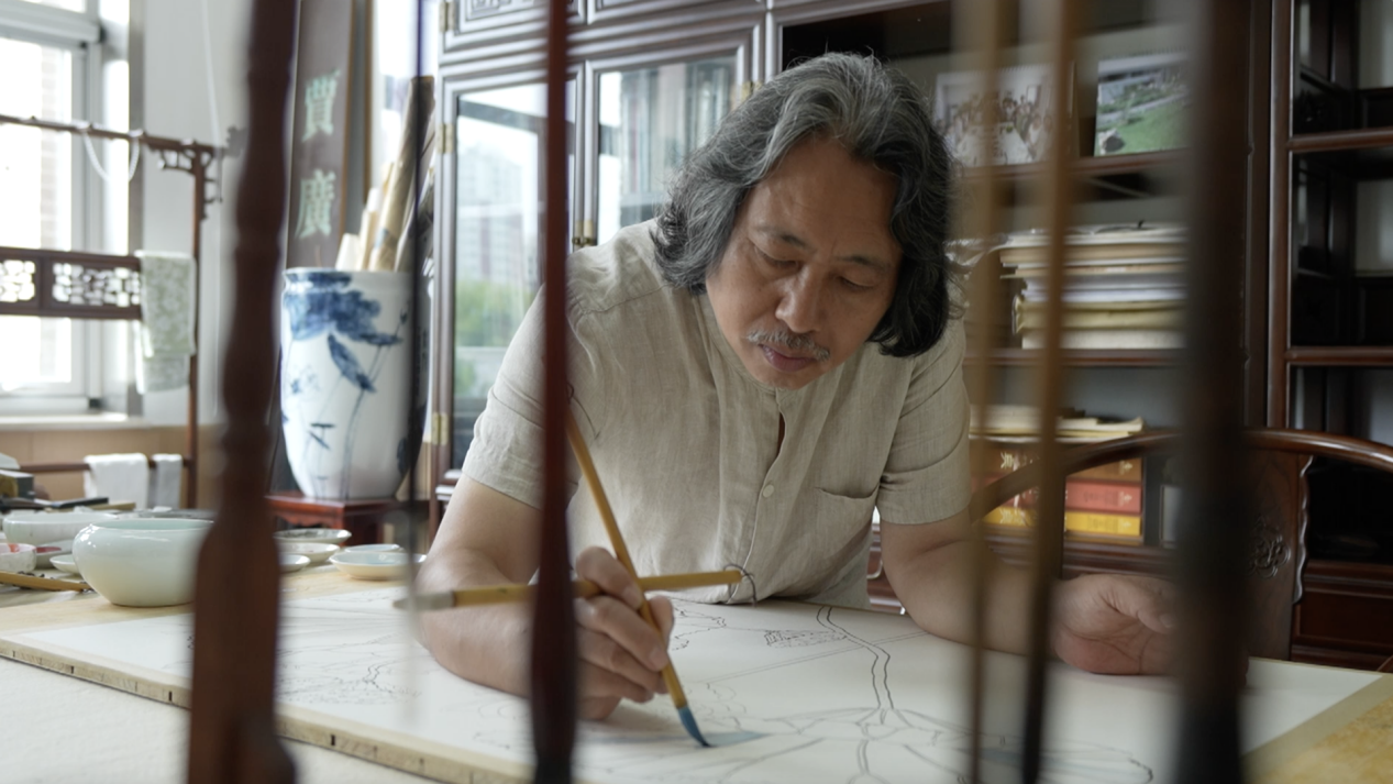 Chinese painter Jia Guangyan working in his studio.  / CMG