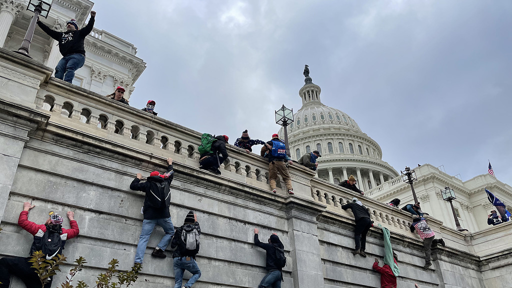 Pro-Trump protesters climb the wall to enter the Capitol building complex in a riot in Washington, D.C., U.S., January 6, 2021. /CFP 