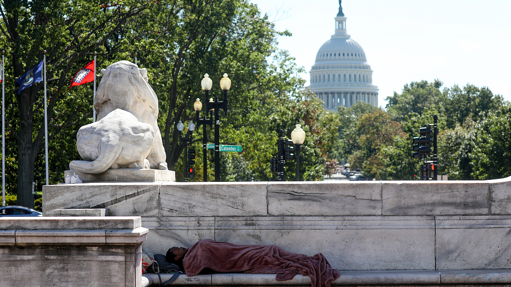 A homeless person asleep on a monument in Washington, D.C., the U.S., October 6, 2021. /CFP