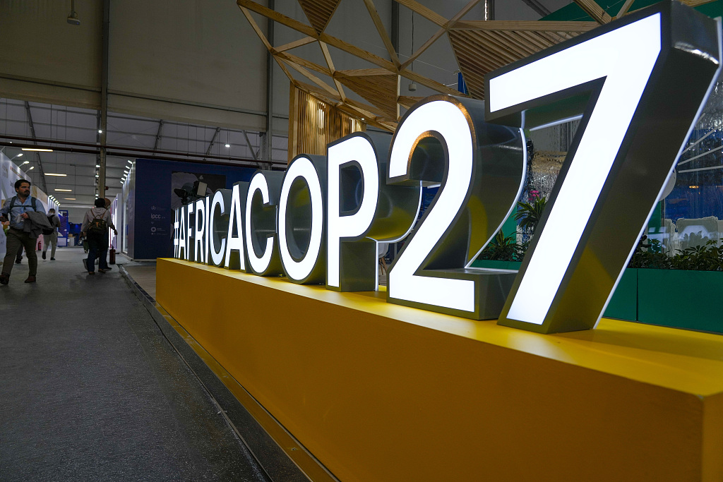 People pass a booth at the convention center hosting the COP27 UN Climate Change Conference on Nov 5, 2022, in Sharm El-Sheikh, Egypt. The city will host the COP27 starting on Nov. 6, and scheduled to end on November 18. /VCG