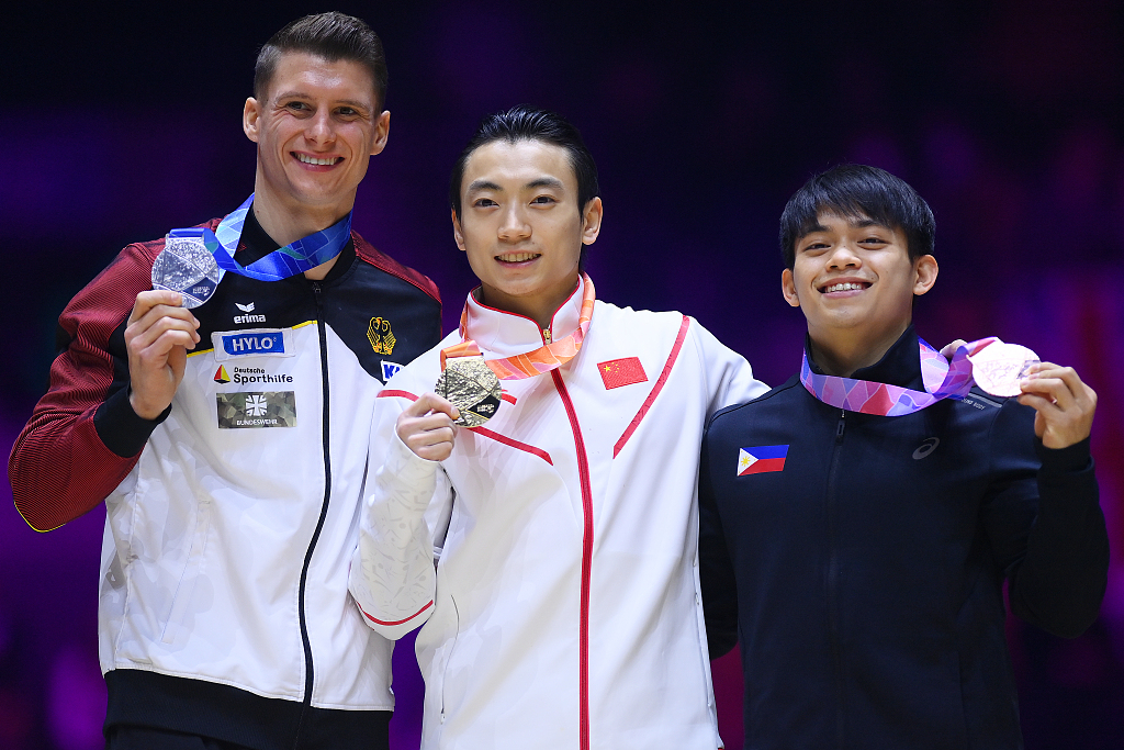 Gold medalist Zou Jingyuan (C) of China, silver medalist Lukas Dauser (L) of Germany and bronze medalist Carlos Edriel Yulo (R) of Philippines during the award ceremony for men's parallel bars final at the World Gymnastics Championships in Liverpool, England, November 6, 2022. /CFP