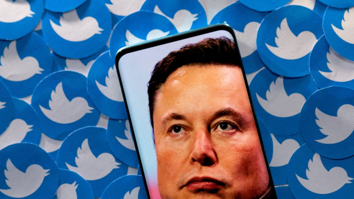 An image of Elon Musk is seen on a smartphone placed on printed Twitter logos in this picture illustration taken April 28, 2022. /Reuters