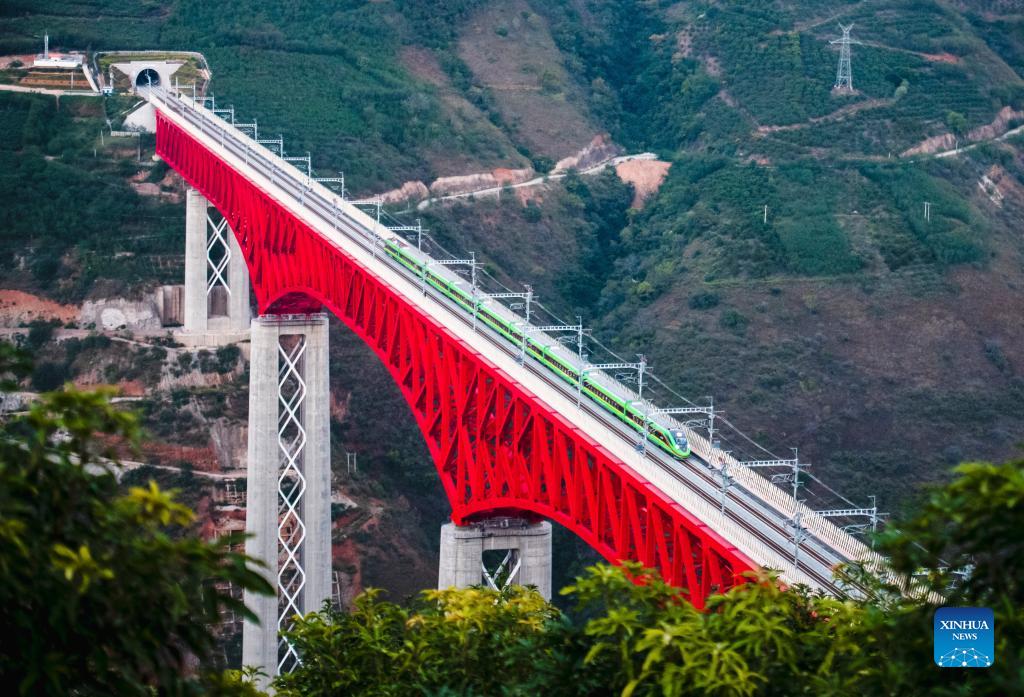 An electric multiple unit train of the China-Laos Railway crosses a major bridge over the Yuanjiang River in southwest China's Yunnan Province, December 3, 2021. /Xinhua