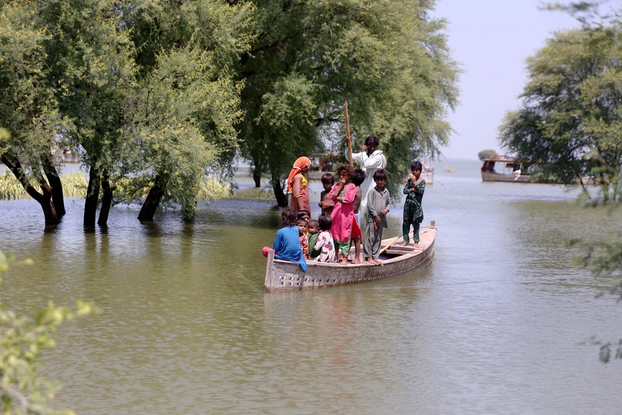 Flood-affected people travel on a boat in flood-hit Dadu district in Pakistan's Sindh province, August 31, 2022. /Xinhua