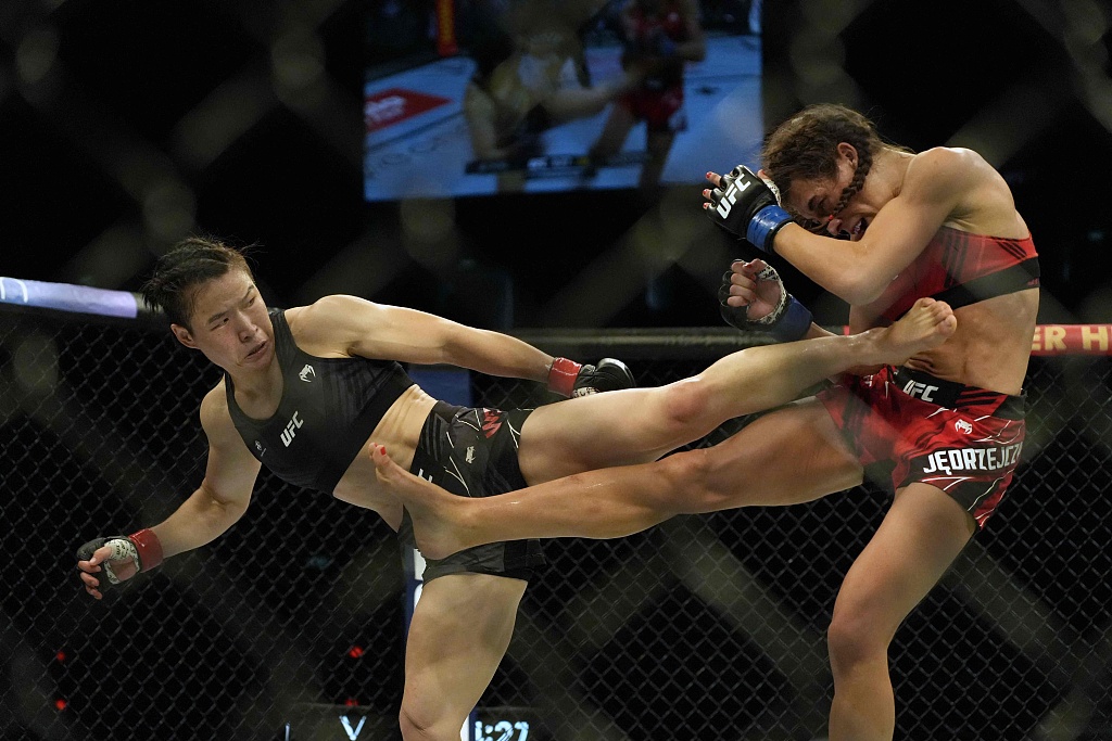 Zhang Weili (L) kicks Joanna Jedrzejczyk of Poland in the belly during the women's strawweight bout in the Ultimate Fighting Championship (UFC) 275 event in Singapore, June 12, 2022. /CFP