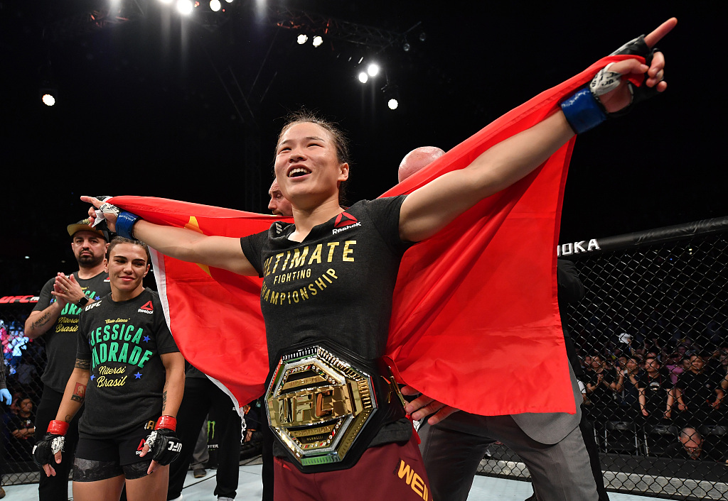 Zhang Weili (C) celebrates with the Ultimate Fighting Championship (UFC) Women's Strawweight title belt after her knockout victory over Jessica Andrade of Brazil during their UFC Strawweight Championship bout in the UFC Fight Night event at Shenzhen Universiade Sports Centre in Shenzhen, south China's Guangdong Province, August 31, 2019. /CFP