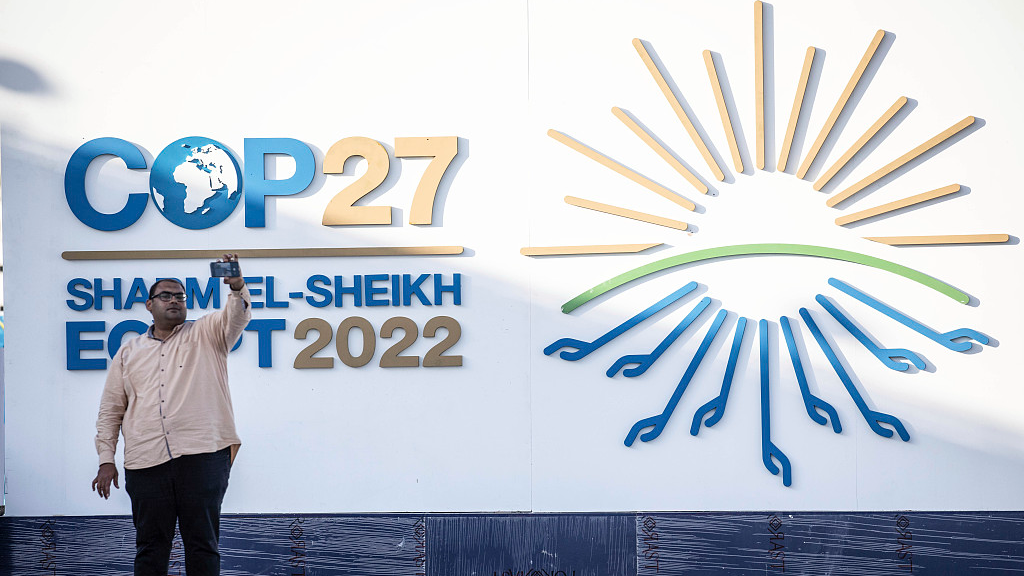 A man takes a selfie with the logo of the 27th session of the Conference of the Parties to the United Nations Framework Convention on Climate Change, at the International Convention Center in Sharm El-Sheikh, Egypt. November 5, 2022. /CFP