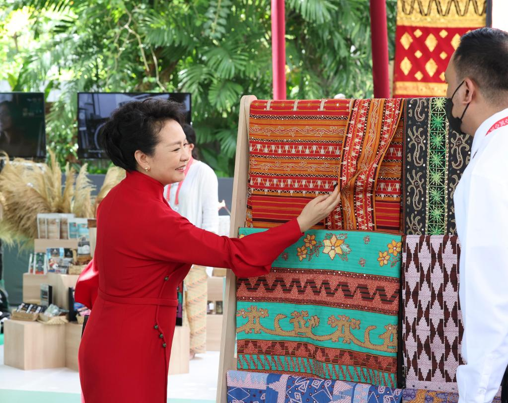 Peng Liyuan, wife of Chinese President Xi Jinping, examines Indonesian embroidery during the exhibition in Bali, Indonesia, November 15, 2022. / Xinhua
